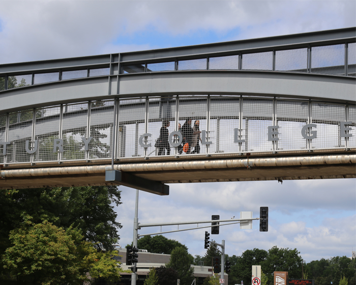 Students crossing the pedestrian bridge from west to east campus at Century College.