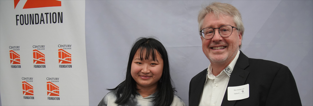 An Asian-American female student accepts her scholarship award from the donor.