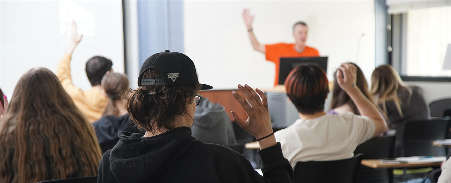 Students raising their hands for a headcount in Human Geography.