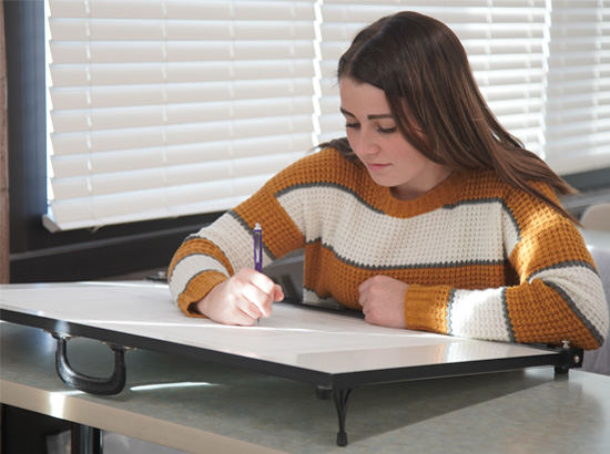 A student working on an easel in the Interior Design classroom.