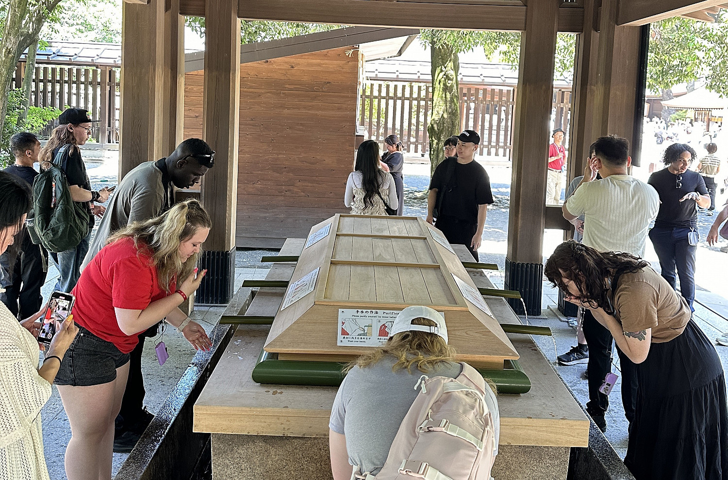 SPR24 study abroad students partaking in the cleansing ceremony at the Meiji Shrine.